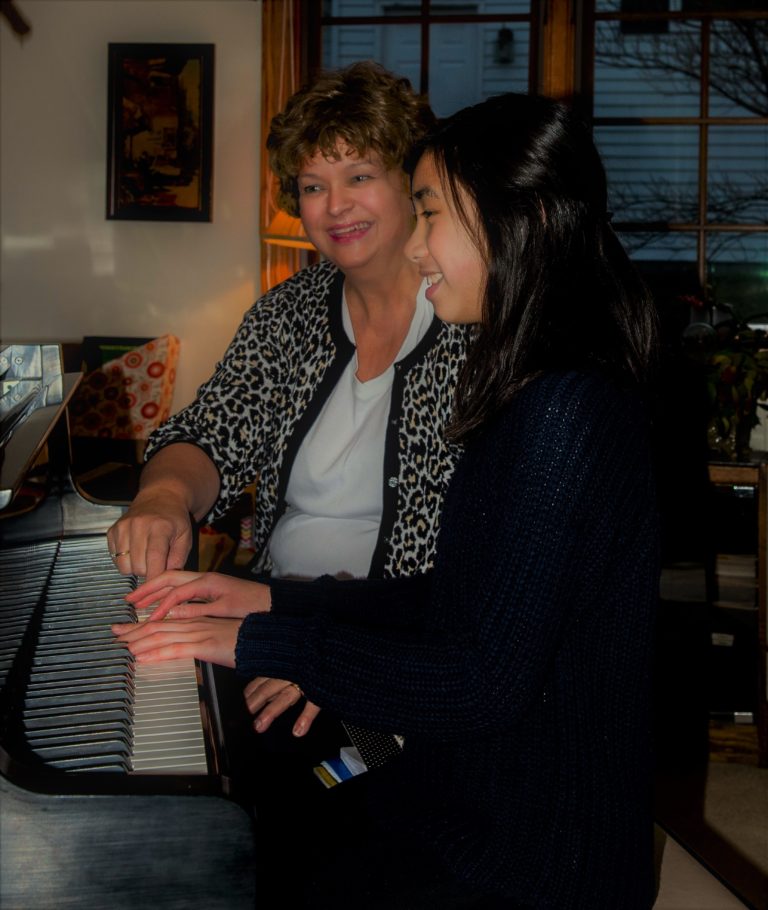 child and teacher at piano during lesson