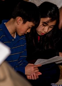 Two young people reading music lyric